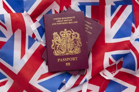 United Kingdom travel passport on a Great Britain Union Jack flagの写真素材