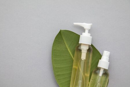 Organic natural cosmetic product with a green leaf on a grey backgroundの写真素材