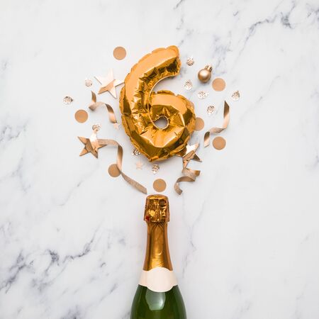 Champagne bottle with gold number 6 balloon. Minimal party anniversary conceptの写真素材