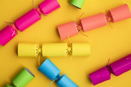 Bright colourful Christmas crackers on a yellow background. festive layflatの写真素材