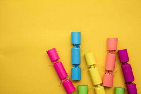 Bright colourful Christmas crackers on a yellow background. festive layflatの写真素材