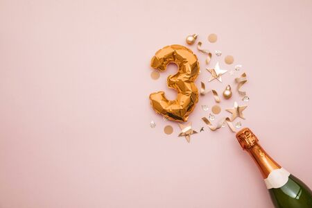 Happy 3rd anniversary party. Champagne bottle with gold number balloon.
