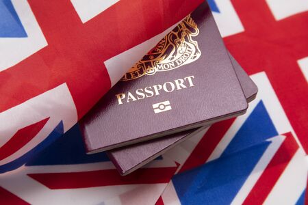 United Kingdom travel passport on a Great Britain Union Jack flagの写真素材