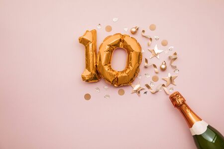 Happy 10th anniversary party. Champagne bottle with gold number balloon.の写真素材