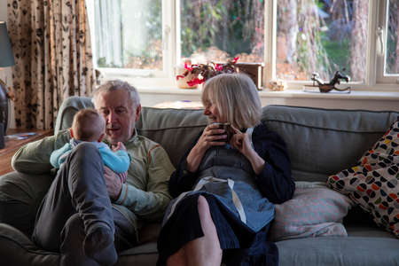 Grandparents play with grandson at home