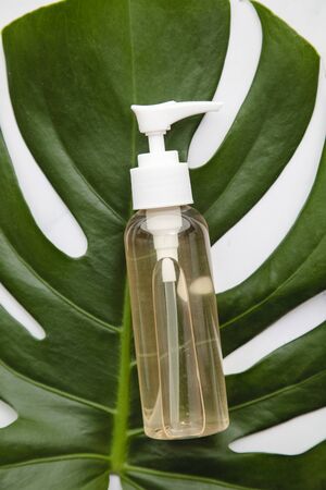 Cosmetic products on a marble background with tropical palm leafの写真素材