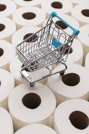 Supermarket shopping trolly on a background of toilet paper rollsの写真素材