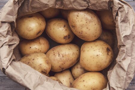 Close up of fresh homegrown potatoes on a wooden backgroundの写真素材