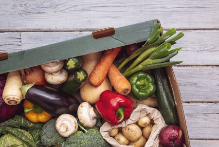 Fresh organic vegetable delivery box on a wooden backgroundの写真素材