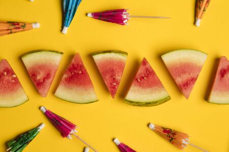 Watermelon and cocktail umbrella tropical summer lay flat backgroundの写真素材