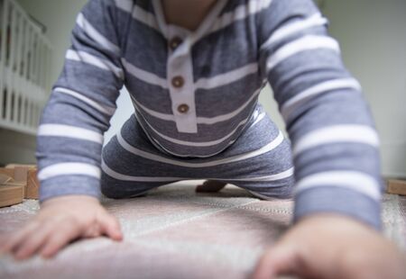 Close up of a baby as they attempt to crawl towards the cameraの写真素材