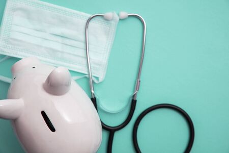 Cost of healthcare. Piggy bank money box with a medical doctors stethoscope