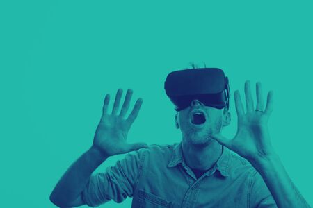 Man in his 30's wearing a VR virtual reality headset. Graphic duotone styleの写真素材