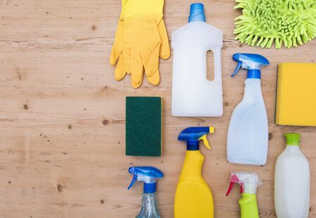 Cleaning spray bottles and cloth lay flat composition on a wooden backgroundの写真素材