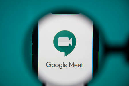 LONDON, UK - May 22 2020: Google Meet video meeting logo under magnifying glass