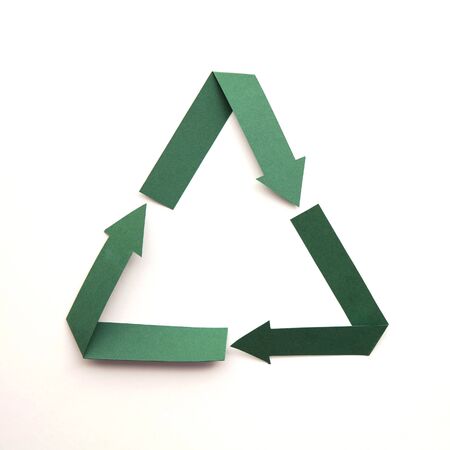 Recycling symbol made from green folded paper