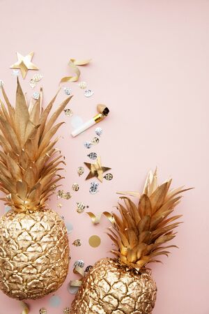 Flat lay tropical pineapple and confetti party celebration backgroundの写真素材