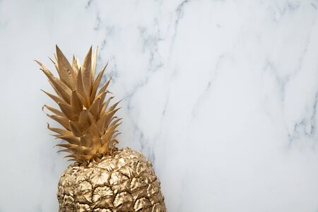trendy tropical gold pineapple on a marble background top viewの写真素材