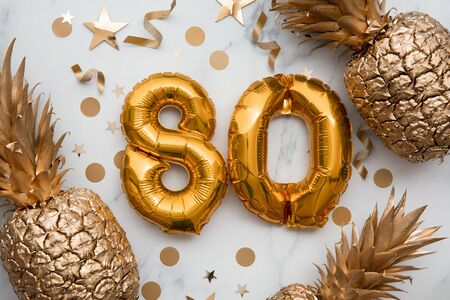 80th birthday celebration card with gold foil balloons and golden pineapplesの写真素材