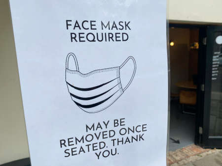 Protective face mask required sign outside a restaurantの写真素材