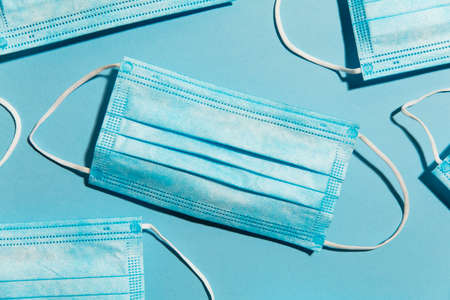Blue surgical medical mask lay flat composition. healthcare concept