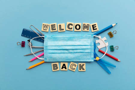 Welcome back to school concept. School supplies with a face mask