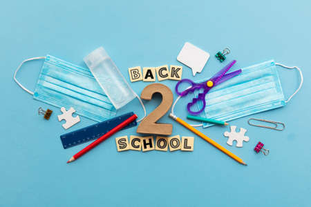 Back to school concept. School supplies with a medical face mask