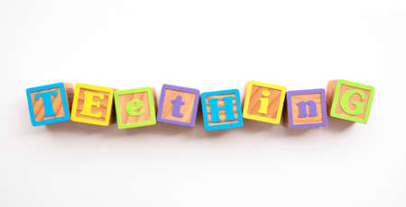 Teething word made from colourful wooden baby development blocksの写真素材
