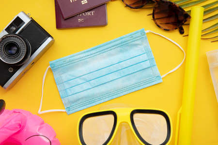 Covid travel background. Holiday essentials with a face maskの写真素材