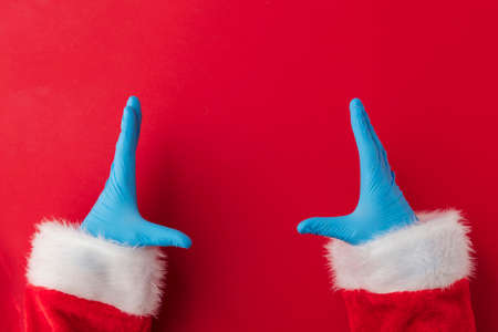 Santa hands wearing blue PPE protective gloves making frame with handsの写真素材