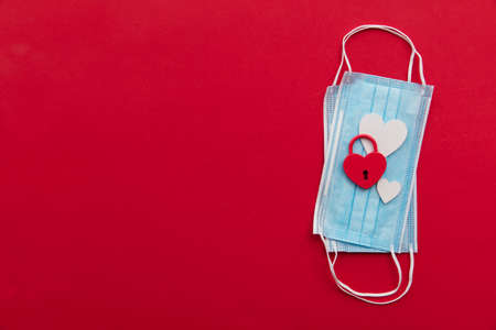 Lovers in lock down. valentine heart padlock on protective face maskの写真素材
