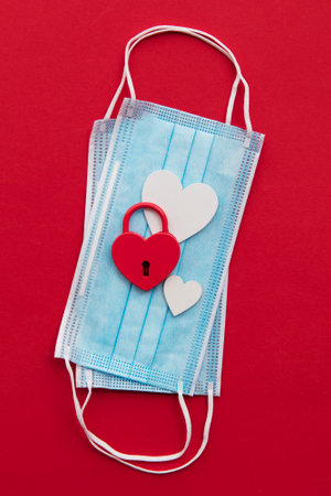 Lovers in lockdown. valentine heart padlock on protective face mask