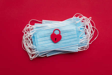 Red valentine padlock heart on protective face masks.の写真素材
