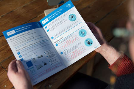 OXFORD, UK - February 2020: A woman reads the government Covid-19 home test kit