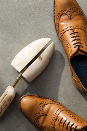 Overhead view of a pair of tan brown leather mens formal shoes on concreteの写真素材