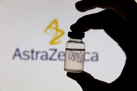 OXFORD, UK - February 2020: Covid vaccine vial in front of the Astrazeneca logoのeditorial素材