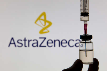 OXFORD, UK - February 2020: Covid vaccine syringe in front of Astrazeneca logoのeditorial素材