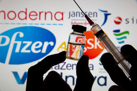 OXFORD, UK - February 2020: Vaccine syringe infront of Covid vaccine logosのeditorial素材