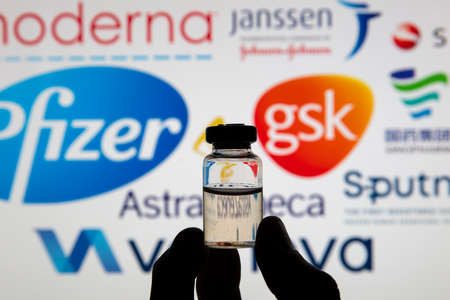 OXFORD, UK - February 2020: Vaccine dose bottle infront of Covid vaccine logosのeditorial素材