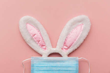 Easter bunny face made from rabbit ears and a protective face maskの写真素材