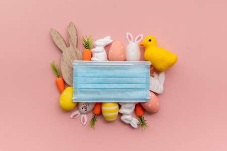 Easter springtime coronavirus background. Protective face mask with easter decorationsの写真素材