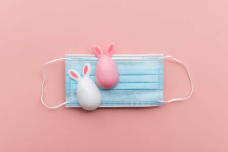 Easter springtime coronavirus background. Protective face mask with easter decorationsの写真素材