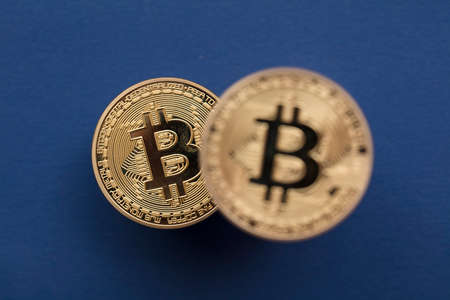 Bitcoin cryptocurrency blockchain gold coins on a blue backgroundの写真素材
