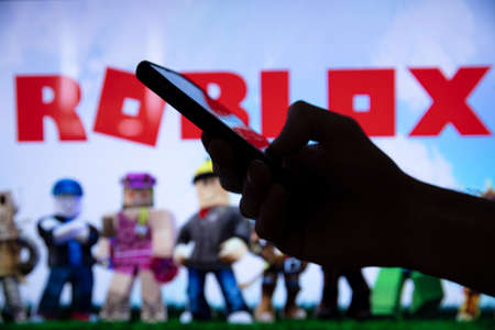 LONDON, UK - March 2021: Person holding a smartphone with Roblox game logoのeditorial素材