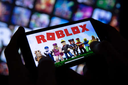 LONDON, UK - March 2021: Person holding a smartphone with Roblox game logoのeditorial素材
