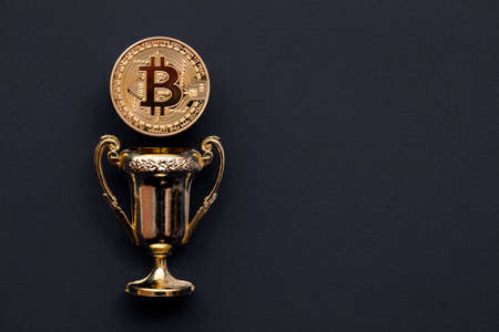 Gold bitcoin cryptocurrency coin with a winning golden trophy