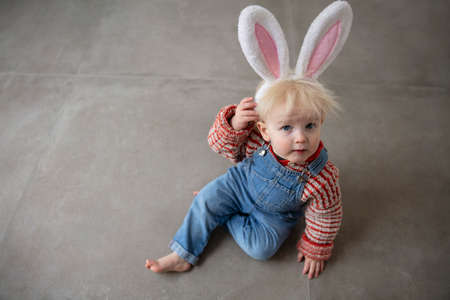 Cute little toddler boy celebrating Easter wearing easter bunny ears