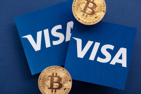 LONDON, UK - March 2021: Bitcoin cryptocurrency on Visa financial service logoのeditorial素材