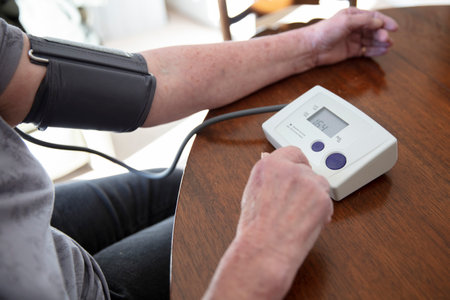 An older senior woman checks her blood pressure at home. Health care concept