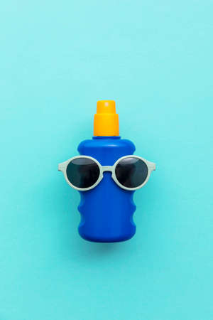 Summer holiday vacation background. Bottle of sun cream with sunglasses